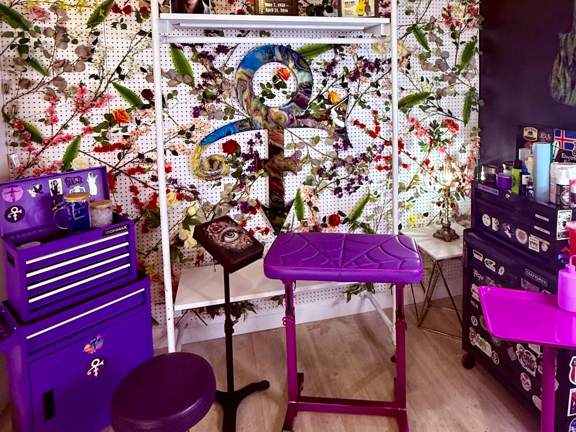 The Prince corner of the Apollonia Ink studio, with a purple tool chest, a purple armrest and the Prince symbol set into the floral wall