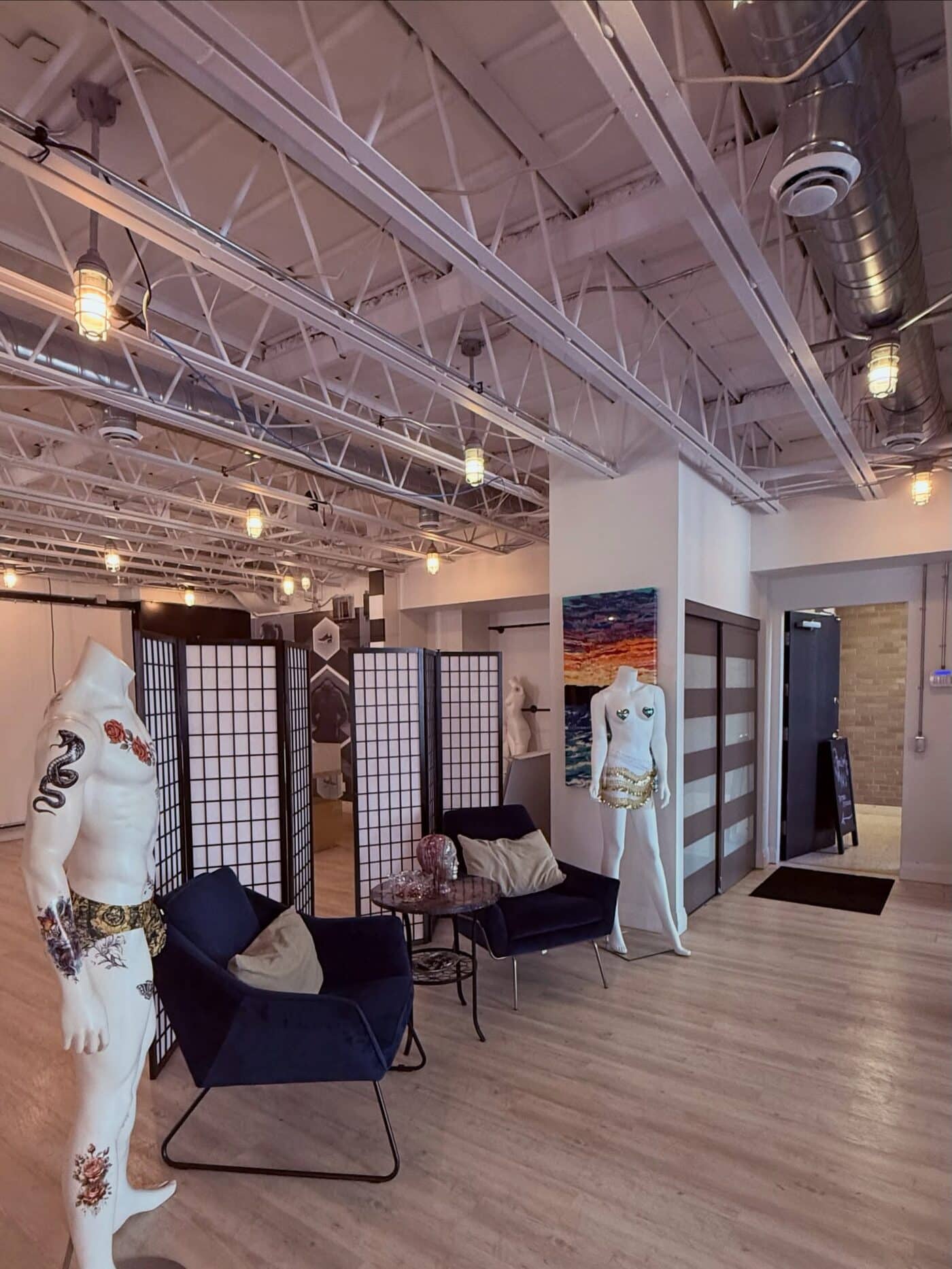 The front of the studio, with folding screens, seating and two mannequins